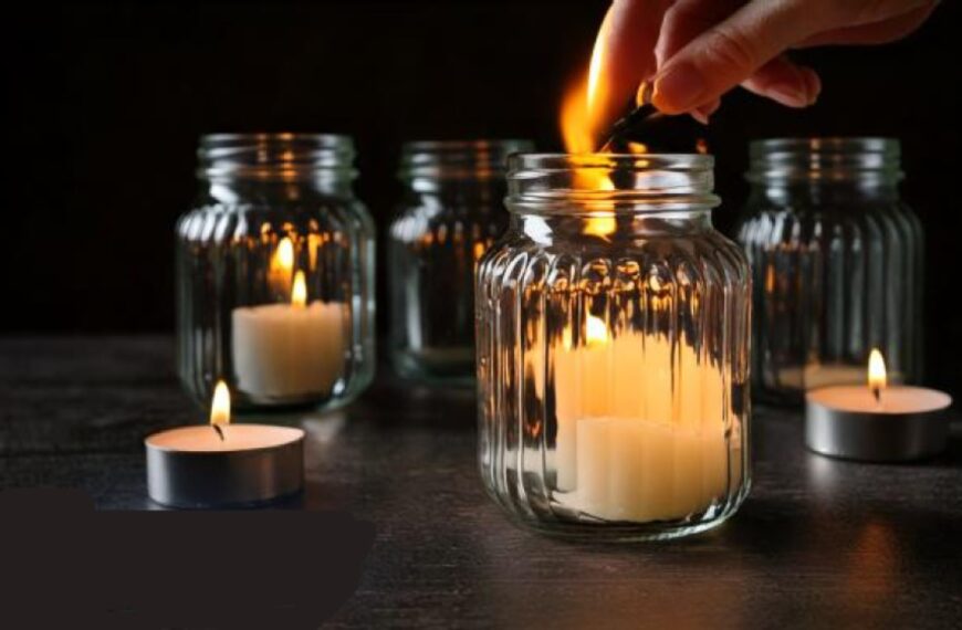 left candle burning in glass jar